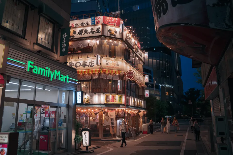 Tokyo street illuminated with neon signs and bustling nightlife, showcasing vibrant urban culture.