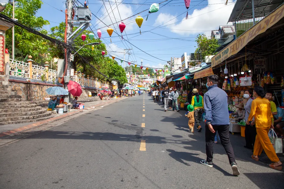 Bustling city street market scene in Vietnam with colorful lanterns and lively atmosphere.