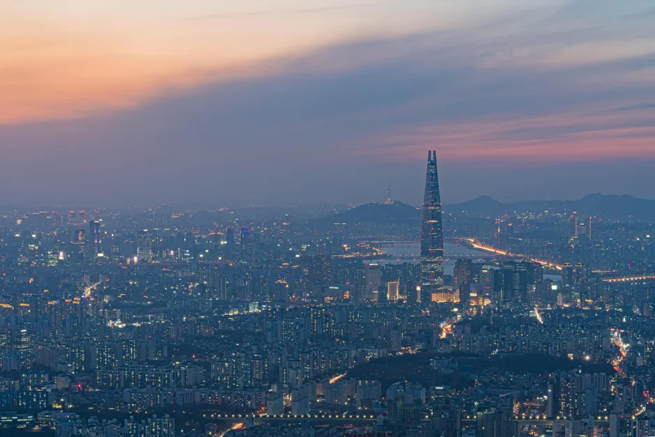 Captivating sunset skyline of Seoul featuring modern skyscrapers and the iconic Lotte World Tower.