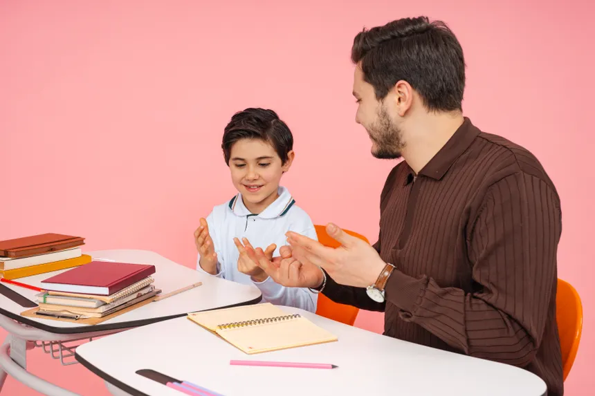 Male teacher and young student enjoying a learning session in a classroom.