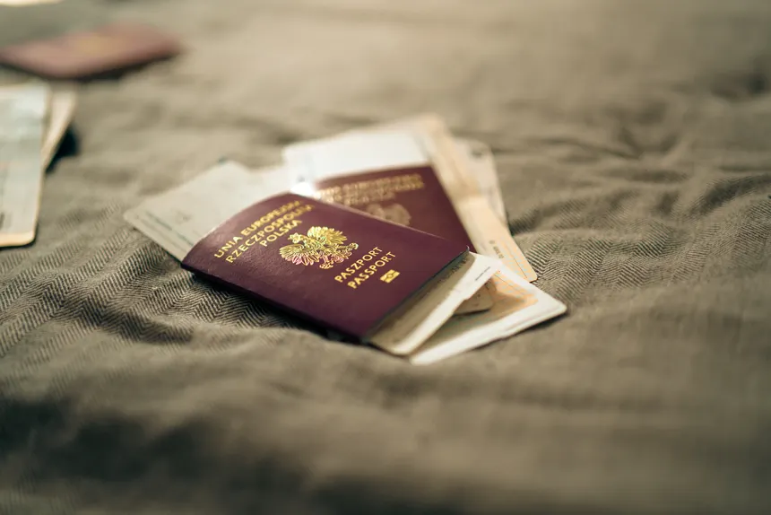 A close-up of a Polish passport and travel documents placed on a fabric surface, symbolizing travel and identity.